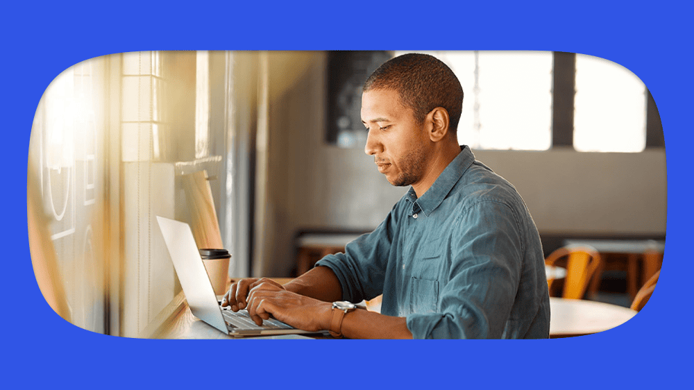 Homem consultando seu seguro defeso pelo cpf em um laptop em ambiente de escritório.