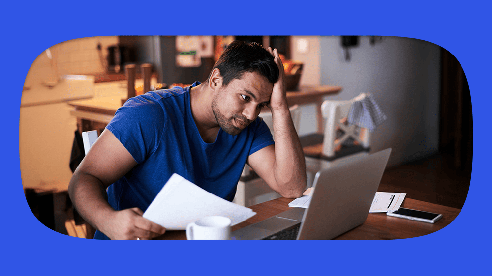 Homem preocupado com restrição do CPF, com um computador portátil, em um ambiente doméstico confortável.